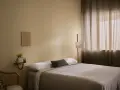 Ett lugnt sovrum med beige väggar, en bekväm säng och en golvlampa. Perfekt för att måla sovrum i en avkopplande stil.
