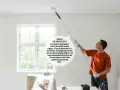Man målar taket med en lång teleskopskaft för att underlätta arbetet. Att måla med struktur roller blir enklare med rätt verktyg.