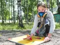 Ung flicka med munskydd skapar graffiti på papper utomhus.