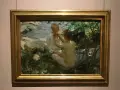 Anders Zorn fångar två barn vid en bäck. En flicka klär på en pojke i solljus.