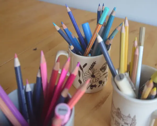 Färgglada pennor i muggar, redo för nya rit tips. En härlig samling för kreativitet.