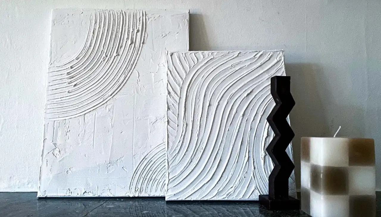 Två vita spakel tavlor med textur, en mörk zig-zag figur och en rutig ljusbrun och vit ljus.