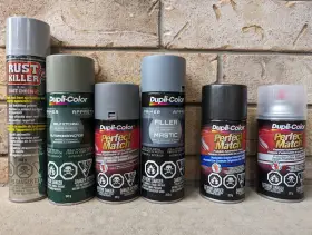 Flera burkar med sprayfärg, inklusive primer och rostskydd, redo att spraymåla taket.